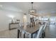 Open concept dining room with wood table and modern chandelier next to bright, updated kitchen at 10844 N 37Th St, Phoenix, AZ 85028
