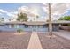 Charming single-story home with blue painted brick and a well-manicured, desert landscaped front yard at 10844 N 37Th St, Phoenix, AZ 85028