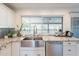 Bright kitchen featuring a stainless steel farmhouse sink, granite counters, and a view of the backyard at 10844 N 37Th St, Phoenix, AZ 85028
