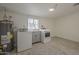 An organized laundry room features modern appliances and updated flooring with natural light at 10844 N 37Th St, Phoenix, AZ 85028