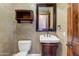 This quaint half-bath has textured walls, wooden cabinets, and a stylish mirror at 11141 E North Ln, Scottsdale, AZ 85259