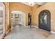 Elegant foyer boasts an arched entryway, decorative iron door, and travertine floors at 11141 E North Ln, Scottsdale, AZ 85259