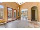 Bright foyer with travertine flooring and natural light pouring through the glass paneled door and window at 11141 E North Ln, Scottsdale, AZ 85259