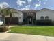 Charming home with a stone archway entry, complemented by a well-manicured lawn and a decorative palm tree at 11141 E North Ln, Scottsdale, AZ 85259