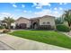 Beautiful home exterior with a lush green lawn, desert landscaping, and a stone-accented entryway at 11141 E North Ln, Scottsdale, AZ 85259