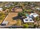 Wide-angle aerial showcasing pool, horse arena, and home with solar panels at 11823 N 76Th Way, Scottsdale, AZ 85260