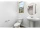 Powder room with pedestal sink, and modern fixtures with a view to the front yard at 12373 W Marguerite Ave, Avondale, AZ 85323