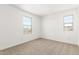 Bedroom boasts neutral carpet, white walls, and natural light through ample windows at 12373 W Marguerite Ave, Avondale, AZ 85323
