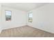 Bedroom with neutral carpet, two windows, and neutral paint at 12373 W Marguerite Ave, Avondale, AZ 85323