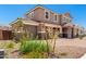 Stunning two-story home boasts a three-car garage, manicured landscaping, and a durable tile roof against a clear sky at 12373 W Marguerite Ave, Avondale, AZ 85323