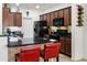 Well-equipped kitchen with black appliances, dark cabinets, and a breakfast bar area with seating at 1475 N Agave St, Casa Grande, AZ 85122