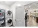 Bright laundry room with stacked white washer and dryer and metal shelving at 1475 N Agave St, Casa Grande, AZ 85122