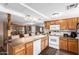 Eat-in kitchen featuring wood cabinets, white appliances, and a breakfast bar at 1779 S 74Th St, Mesa, AZ 85209