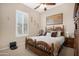 Cozy bedroom with a wooden bed frame, shutters, neutral paint, and an elegant decorative painting at 19712 N Bridge Ct, Maricopa, AZ 85138