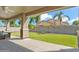 Covered patio overlooking a backyard with green grass, palm trees, and a privacy fence at 25776 N Sandstone Way, Surprise, AZ 85387