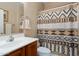 Bathroom with a light wood vanity, sink, and a patterned shower curtain at 25776 N Sandstone Way, Surprise, AZ 85387
