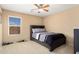 Bedroom with a window, carpeted floor, dark wooden bed frame and grey bedding at 25776 N Sandstone Way, Surprise, AZ 85387