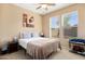 Well-lit bedroom with a ceiling fan, windows, a bed and a side table at 25776 N Sandstone Way, Surprise, AZ 85387