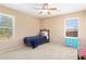 Bright bedroom with a ceiling fan, large window, bed and blue accent furniture at 25776 N Sandstone Way, Surprise, AZ 85387