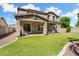Two-story home with covered patio overlooking a green lawn, ideal for outdoor enjoyment at 25776 N Sandstone Way, Surprise, AZ 85387