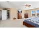 Spacious main bedroom featuring a ceiling fan, TV, dressers, and an open closet at 25776 N Sandstone Way, Surprise, AZ 85387