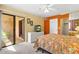 Bedroom with sliding door to balcony, ceiling fan, and tropical-themed bedspread at 3031 N Civic Center Plz # 306, Scottsdale, AZ 85251