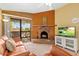 Cozy living room with a decorative brick fireplace, comfortable seating, and balcony access at 3031 N Civic Center Plz # 306, Scottsdale, AZ 85251