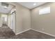 Bedroom featuring neutral walls, carpeted flooring, and bright natural light, next to barn-door entrance at 3802 E Stiles Ln, Gilbert, AZ 85295