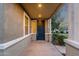 Inviting covered front porch with stylish columns, manicured bushes, attractive black door, and exterior lighting at 3802 E Stiles Ln, Gilbert, AZ 85295