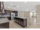Kitchen with granite island, dark cabinets, stainless appliances and open to living area at 3802 E Stiles Ln, Gilbert, AZ 85295