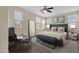 Serene main bedroom with a plush bed, stylish seating area, and abundant natural light from multiple windows at 3802 E Stiles Ln, Gilbert, AZ 85295