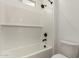 Bathroom with a white tiled shower-tub combo and sleek, modern fixtures at 40563 W Michaels Dr, Maricopa, AZ 85138