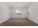 Bright bedroom with neutral carpet and white walls, illuminated by natural light through large windows at 40563 W Michaels Dr, Maricopa, AZ 85138