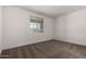 Bedroom featuring neutral carpet, white walls, and a view from a large window at 40563 W Michaels Dr, Maricopa, AZ 85138
