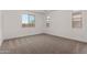 Bright bedroom with neutral carpet, white walls, and natural light from multiple windows at 40563 W Michaels Dr, Maricopa, AZ 85138