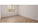 A bright bedroom with tile flooring, a window and neutral walls offers a clean and modern aesthetic at 40563 W Michaels Dr, Maricopa, AZ 85138