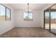 Bright dining area with modern chandelier, large windows, and sliding door access at 40563 W Michaels Dr, Maricopa, AZ 85138