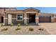 Inviting home featuring a covered porch, desert landscaping, and a two-car garage at 40563 W Michaels Dr, Maricopa, AZ 85138