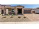 Charming single-story home with desert landscaping, brick driveway, and a two-car garage at 40563 W Michaels Dr, Maricopa, AZ 85138