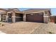 Attached two-car garage with a paved driveway, complemented by desert landscaping at 40563 W Michaels Dr, Maricopa, AZ 85138