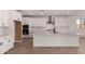 Bright kitchen with white cabinets, stainless steel appliances, and large island with sink at 40563 W Michaels Dr, Maricopa, AZ 85138
