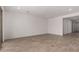 Large, empty living area with tile flooring, recessed lighting, and access to the backyard at 40563 W Michaels Dr, Maricopa, AZ 85138
