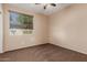 A carpeted bedroom features natural light from its window and ceiling fan for comfort at 4481 N Luna W Rd, Litchfield Park, AZ 85340