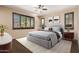 Comfortable bedroom featuring a large bed, plantation shutters, neutral decor, and ample natural light at 4481 N Luna W Rd, Litchfield Park, AZ 85340