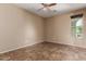 Bright empty room with tile flooring, a ceiling fan, neutral walls, a large window, and an electrical outlet at 4481 N Luna W Rd, Litchfield Park, AZ 85340