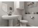 Cozy half-bathroom showcases pedestal sink, toilet, and decorative elephant artwork at 502 E Kona Dr, Casa Grande, AZ 85122