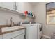Well-lit laundry room features a washer, dryer, sink, and ample storage space at 502 E Kona Dr, Casa Grande, AZ 85122