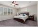 Bedroom showcases a dark wood bed frame, ceiling fan, and bright natural light at 502 E Kona Dr, Casa Grande, AZ 85122