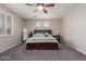 Bedroom features a dark wood bed frame, ceiling fan, and bright natural light at 502 E Kona Dr, Casa Grande, AZ 85122