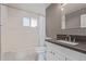 Bright bathroom with white tiled walls, shower-tub combo, gray countertop, and modern fixtures at 520 W Townley Ave, Phoenix, AZ 85021